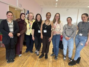 The photo shows Katherine, staff and volunteers from Daniel's Den standing in a hall in a community centre.
